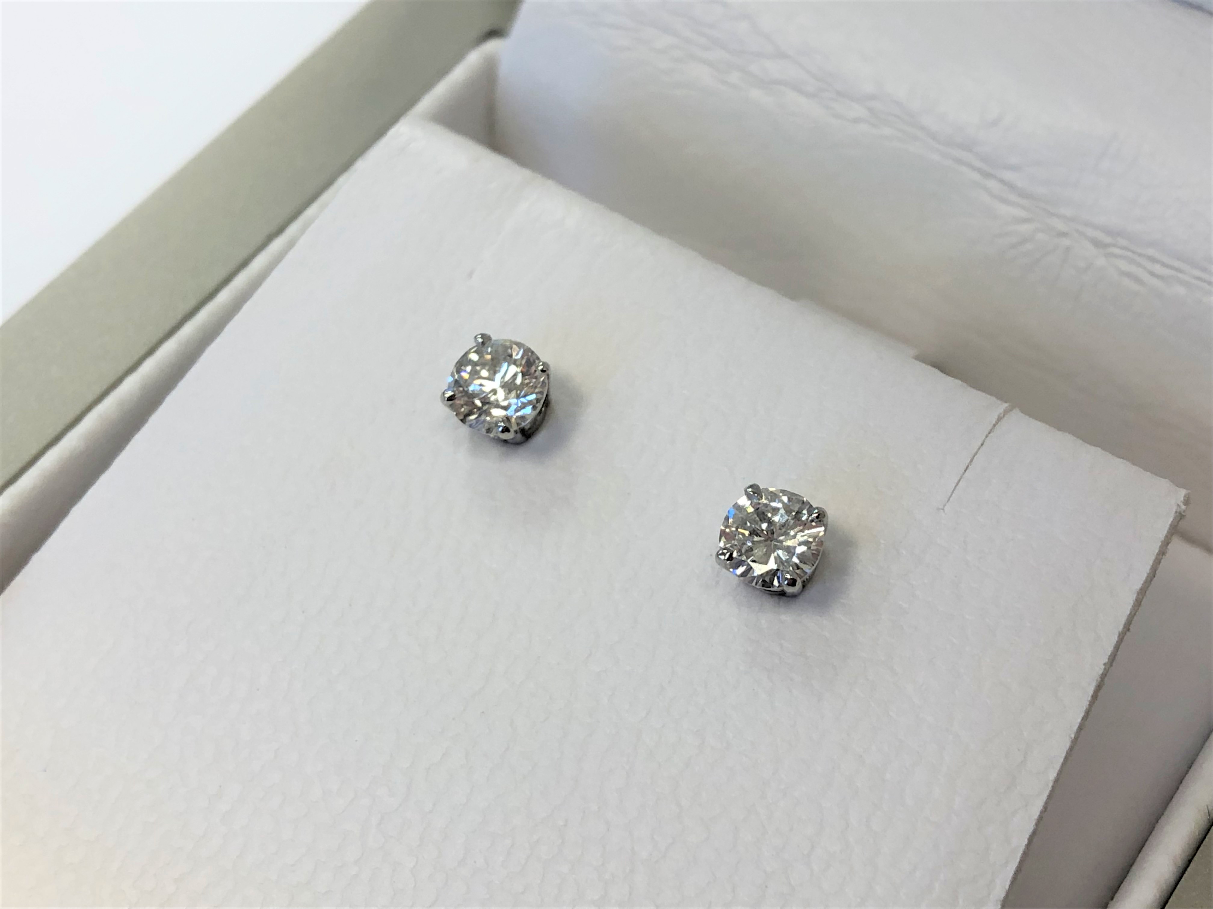 A pair of 18ct white gold diamond solitaire earrings, approximately 0.