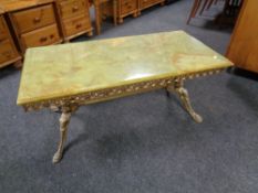 A rectangular onyx topped coffee table on ornate brass base,