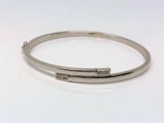 A 9ct white gold diamond set hinged bangle CONDITION REPORT: 4.