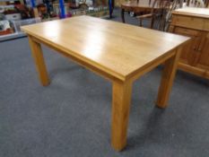 A contemporary oak dining table, length 153 cm,