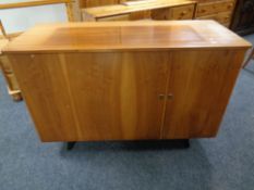 A mid 20th century teak sideboard opening up to reveal a desk,