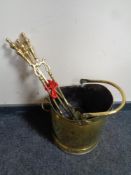 An antique brass swing handled coal bucket together with three brass companion pieces