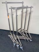 Three metal adjustable clothes rails on casters