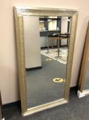 A contemporary bevelled mirror in a silver coloured frame,