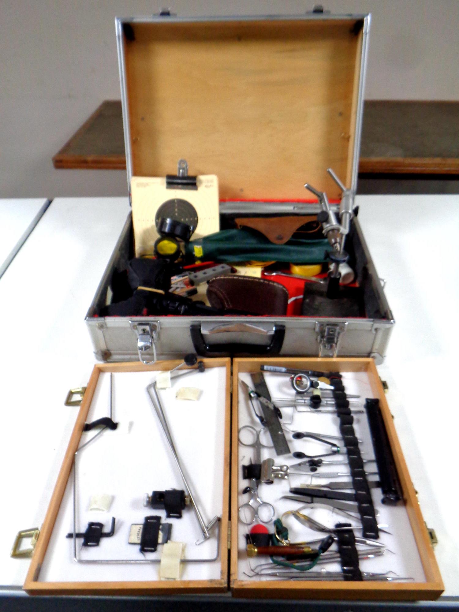 An aluminium case containing shooting equipment to include gun cleaning rods, precision tools,