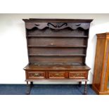 A Georgian oak kitchen dresser fitted three drawers beneath on raised legs, height 206 cm,