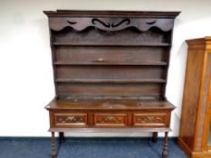 A Georgian oak kitchen dresser fitted three drawers beneath on raised legs, height 206 cm,