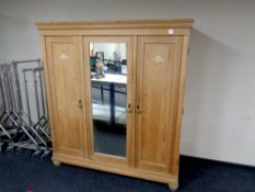 An antique continental pine triple door wardrobe with central mirrored door CONDITION