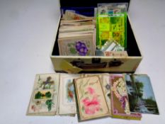 A contemporary case containing antiquarian postcards and 20th century stamps to include Easter