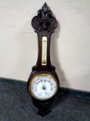 An Edwardian carved oak aneroid barometer