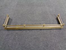 An antique brass fire fender