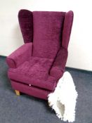 A wingback armchair upholstered in a purple fabric