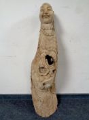 A carved piece of driftwood depicting an eastern goddess and Buddha