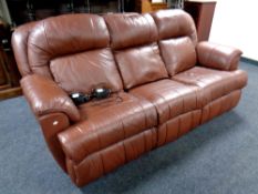 A brown leather three seater electric reclining settee