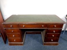 A 19th century mahogany twin pedestal desk fitted nine drawers with a green leather inset panel