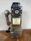 A reproduction telephone in the style of an American 1950s public telephone