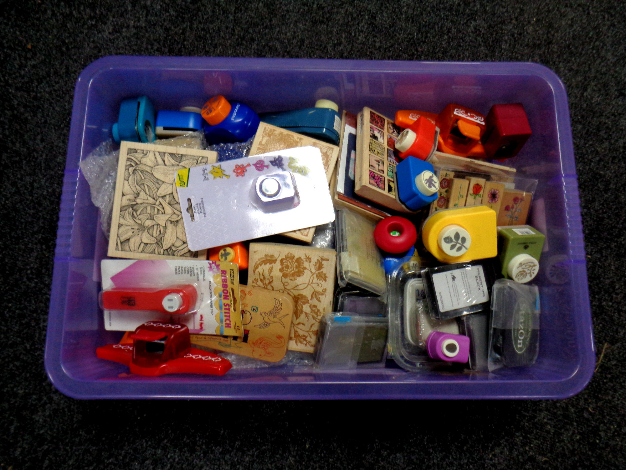 A box containing a large quantity of crafting equipment to include fiskars die cutters, stamps,