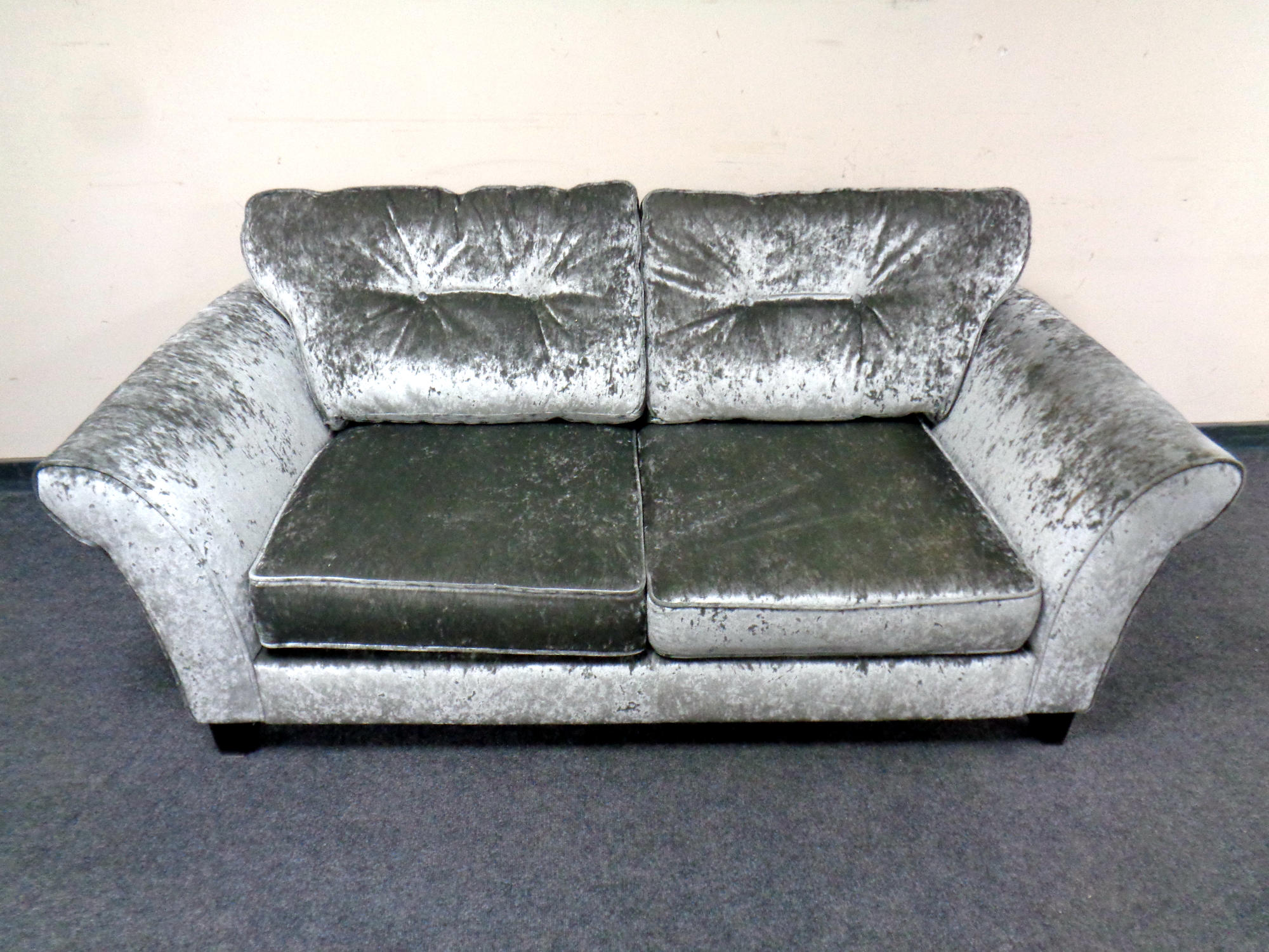 A contemporary two seater settee upholstered in a grey crushed velvet fabric