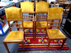 A set of four Edwardian oak chairs comprising of two carvers and two singles upholstered in a gold