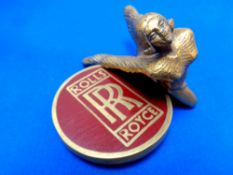 A Rolls Royce Spirit of Ecstasy mascot together with a Rolls Royce badge