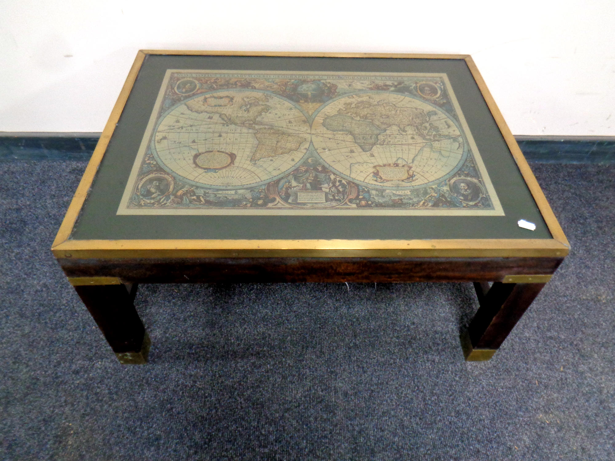 A brass framed coffee table depicting a map of the world