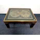 A brass framed coffee table depicting a map of the world