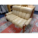 A wood framed two seater settee upholstered in a mustard leather