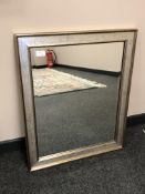 A bevelled mirror in a silver coloured frame,