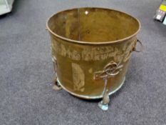 An antique brass Arts and Crafts log bucket on raised feet