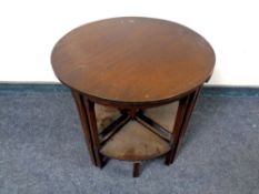 A 20th century circular occasional table fitted four tables beneath