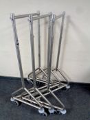 Three metal adjustable clothes rails on casters