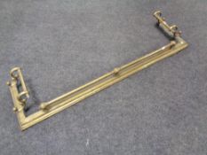 An antique brass fire fender