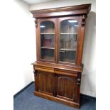 A Victorian style glazed double door bookcase fitted cupboards and drawers beneath