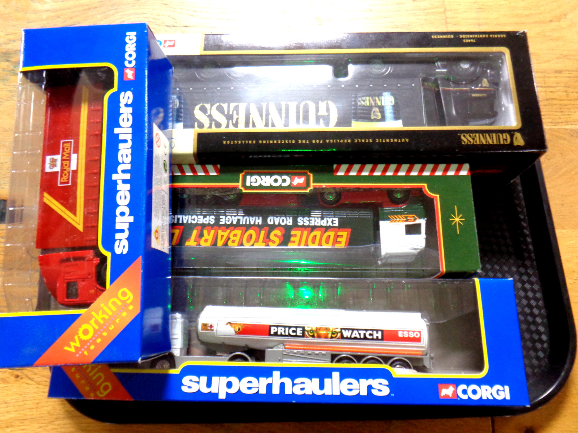 A tray containing four Corgi die cast trucks to include a Superhauliers Esso Scania cab and fuel