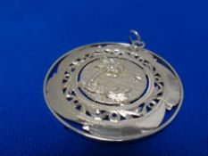 A large circular silver pendant