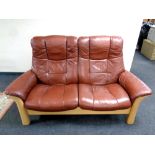 A Stressless wood framed brown leather two seater reclining settee