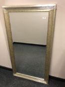 A contemporary bevelled mirror in a silver coloured frame,