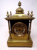 An ornate brass mantel clock on raised feet, with pendulum and key, height 35.