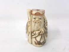 A Japanese carved bone netsuke - Village elder carrying a long staff.