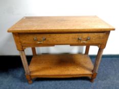 An Edwardian oak two tier serving stand fitted a drawer,