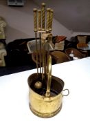A brass swing handled coal bucket and a four piece companion set on stand