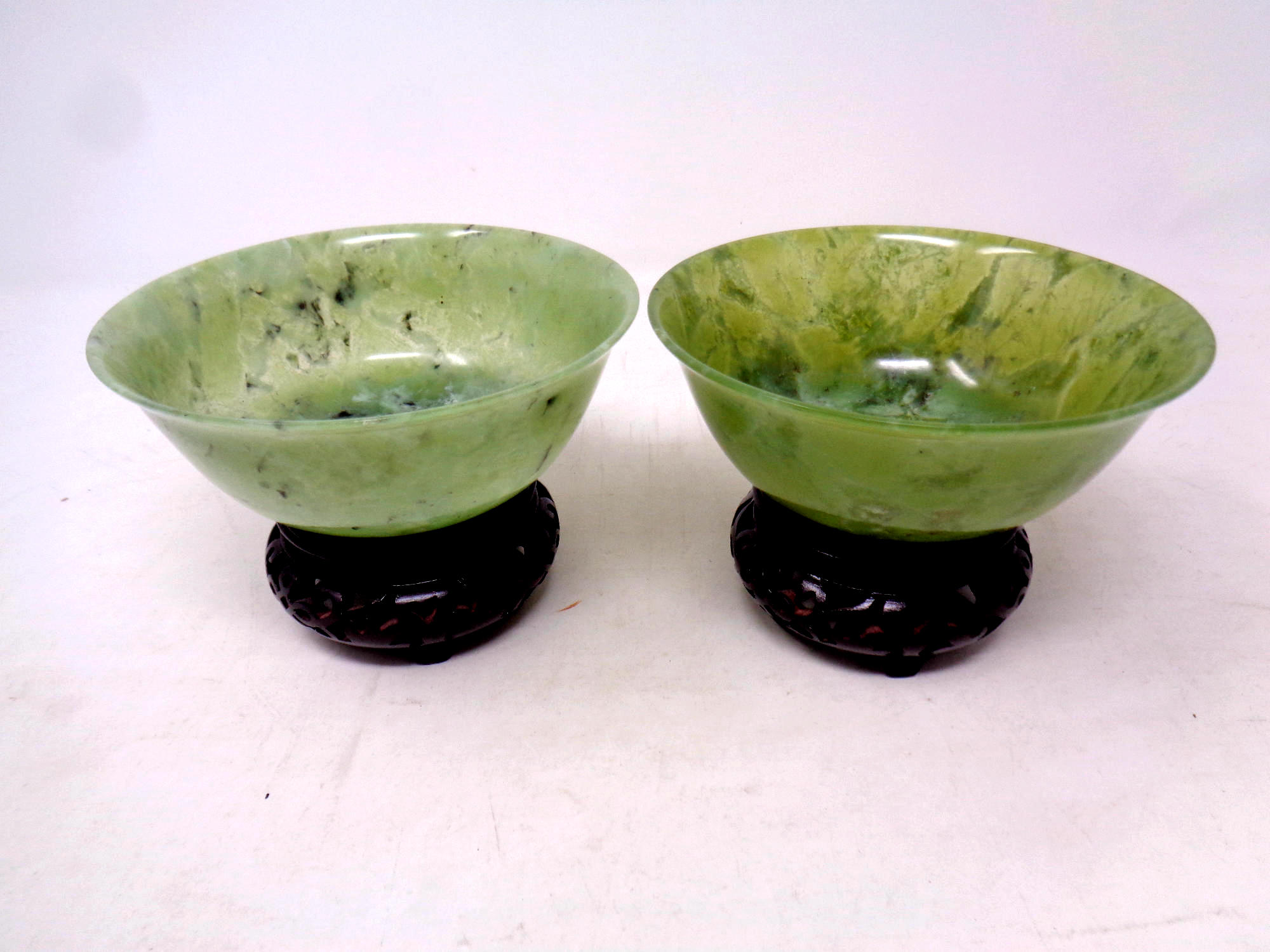Two Chinese jade bowls on wooden stands, diameter 12.