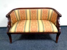 A reproduction Egyptian revival settee in a classical striped fabric,