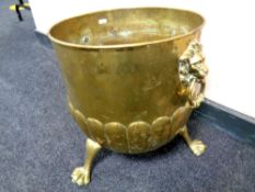 A Victorian brass coal bucket with lion mask handles on paw feet