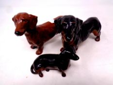 A Beswick figure of a dachshund together with two further Royal Doulton figures,