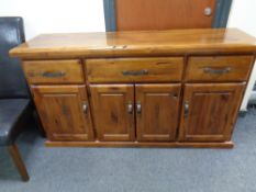 A plantation pine four door sideboard fitted three drawers,