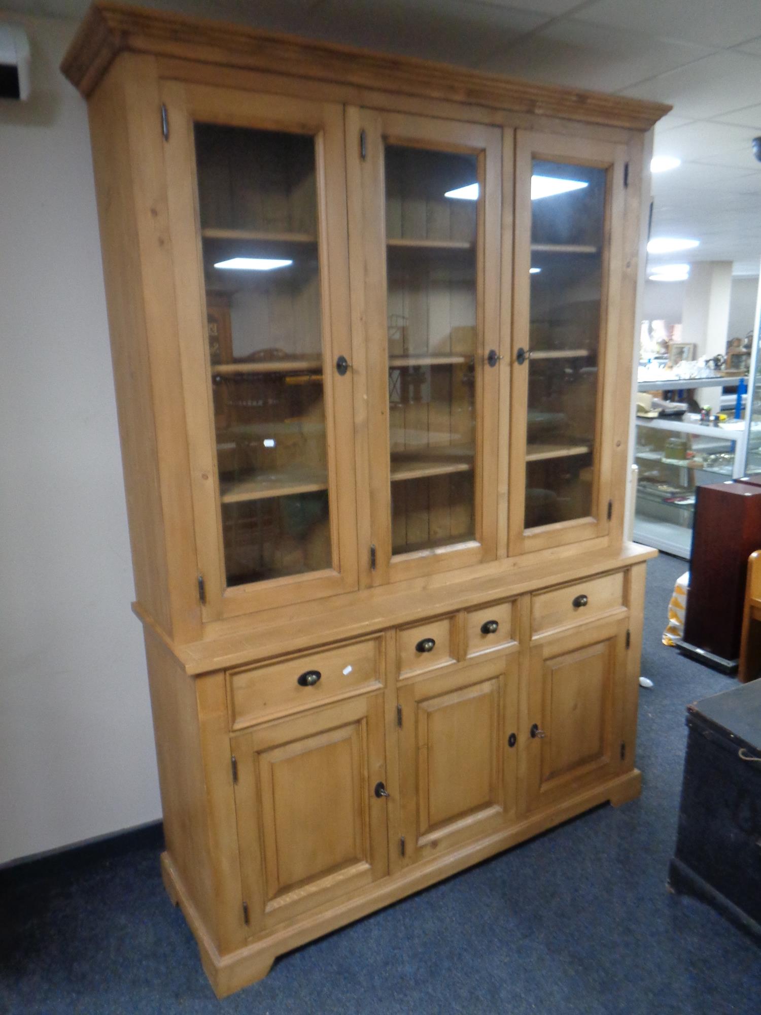 A stripped pine farmhouse kitchen cabinet, fitted cupboards and drawers beneath, width 155 cm,