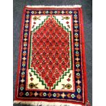 A small eastern rug of geometric design 96cm by 61cm