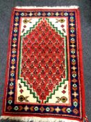 A small eastern rug of geometric design 96cm by 61cm