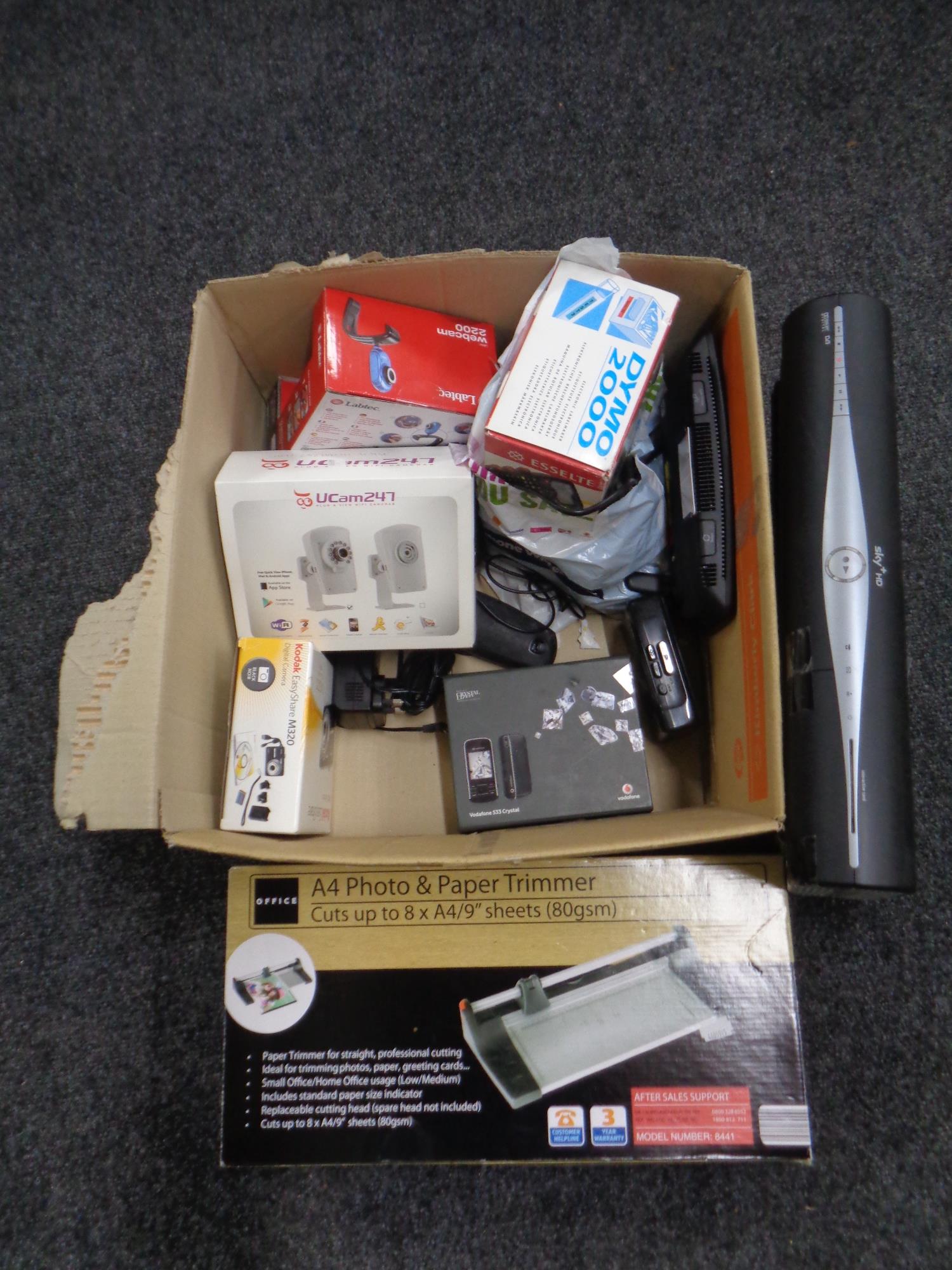 A box containing assorted electricals to include Vodafone phone, wifi camera, BT home hub,